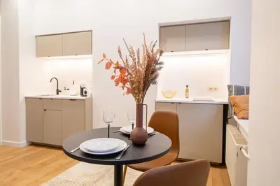 a kitchen and dining room with a table and chairs at Lukiškės Central Apartment - Self Check-in and Parking Option in Vilnius