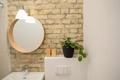 a bathroom with a mirror and a white sink at Lukiškės Central Apartment - Self Check-in and Parking Option in Vilnius