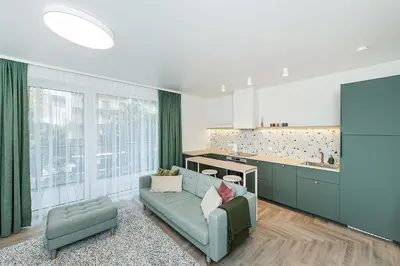 a living room with a blue couch and a kitchen at Cozy Piliamiescio Apartament No 2 by URBAN RENT in Kaunas