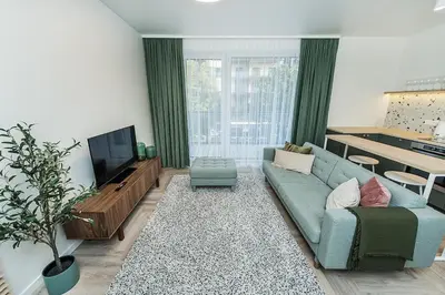 a living room with a blue couch and a tv at Cozy Piliamiescio Apartament No 2 by URBAN RENT in Kaunas