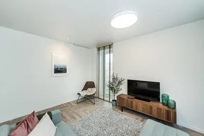 a living room with a tv and a couch at Cozy Piliamiescio Apartament No 2 by URBAN RENT in Kaunas