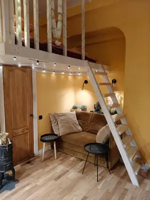 a living room with a couch and a loft bed at Aušros Vartai in Vilnius