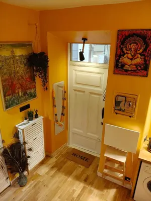 a yellow room with a white door and a window at Aušros Vartai in Vilnius
