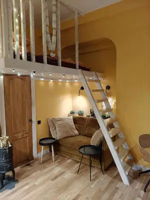 a bedroom with a bed and a loft bed with a staircase at Aušros Vartai in Vilnius