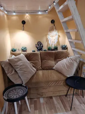 a living room with a brown couch and stairs at Aušros Vartai in Vilnius