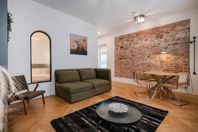 a living room with a couch and a brick wall at Kaunas Old Town Art Deco Apartments II in Kaunas