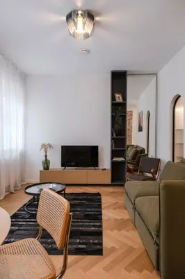 a living room with a couch and a tv at Kaunas Old Town Art Deco Apartments II in Kaunas