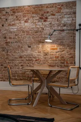 a table and two chairs in front of a brick wall at Kaunas Old Town Art Deco Apartments II in Kaunas