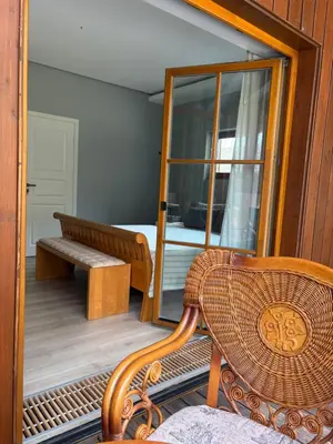 a wicker chair and a bench in a room at Domus Revado in Birštonas