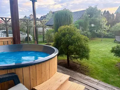 a large hot tub on a deck with a yard at Domus Revado in Birštonas