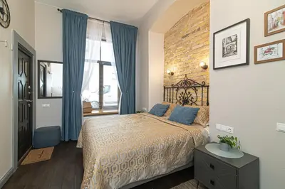 a bedroom with a bed and a brick wall at Old Town Apartments Senora Self Check-in and free parking in Vilnius