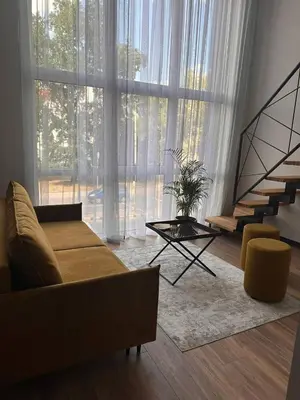 a living room with a couch and a large window at Sunny loft 3 x 24x7 x Close to old town in Vilnius