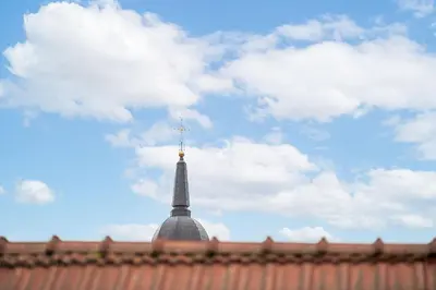 a spire of a building with a sky in the background at Cathedral Square Apartment in Vilnius