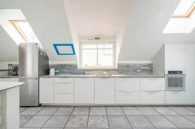 a kitchen with white cabinets and a window at Cathedral Square Apartment in Vilnius