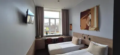 a hotel room with two beds and a window at Private room at Hotel building in Vilnius