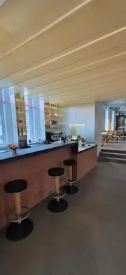 a bar with three stools in a room at Private room at Hotel building in Vilnius