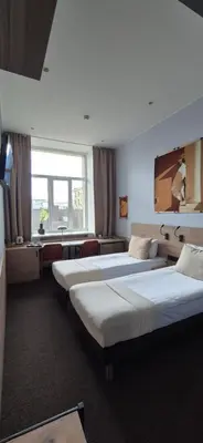 a hotel room with three beds and a desk at Private room at Hotel building in Vilnius