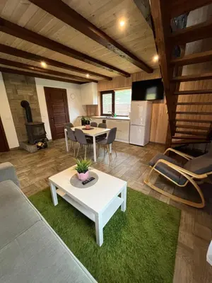 a living room with a white table and a kitchen at Holiday House Strawberry in Druskininkai