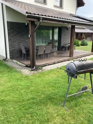 a barbecue grill in the yard of a house at Holiday House Strawberry in Druskininkai