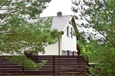 a white house with stairs and trees at Holiday House Strawberry in Druskininkai