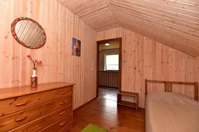 a bedroom with a bed and a dresser and a mirror at Holiday House Strawberry in Druskininkai