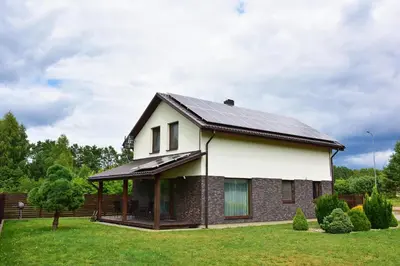 a house with a metal roof on a yard at Holiday House Strawberry in Druskininkai