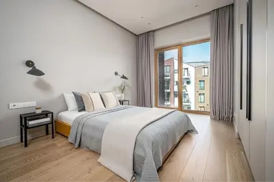a white bedroom with a bed and a large window at Spacious 2 bedroom Luxury Apartment in Vilnius