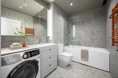 a bathroom with a washer and a toilet and a tub at Spacious 2 bedroom Luxury Apartment in Vilnius