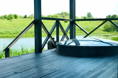 a hot tub on a wooden table with a view of a river at DeerHouse in Kaliakiemiai