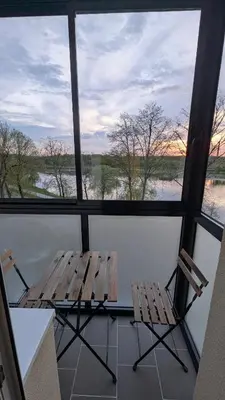 two chairs and a table in a room with windows at Kaunas River-View Retreat Free Parking in Kaunas