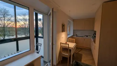 a kitchen with a table and a large window at Kaunas River-View Retreat Free Parking in Kaunas