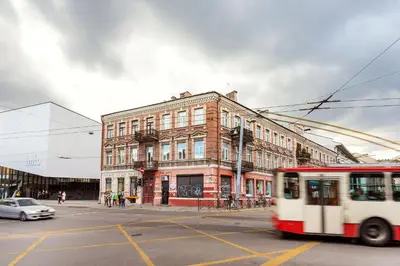 a bus driving down a street in front of a building at Old city gate in Vilnius