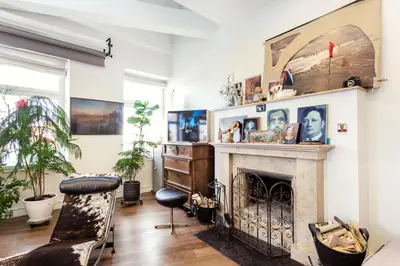 a living room with a fireplace and a chair at Old city gate in Vilnius