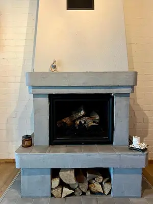 a stone fireplace with logs inside of it at Villa Poilsinė in Balninkai