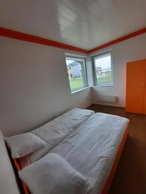 a bedroom with two beds and two windows at Vitkų sodyba in Pakopi
