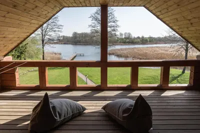 a room with a view of a lake through a window at Rubikių Kranto Sodyba in Anykščiai