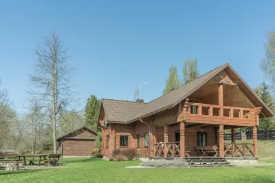 a log cabin with a porch and a deck at Rubikių Kranto Sodyba in Anykščiai