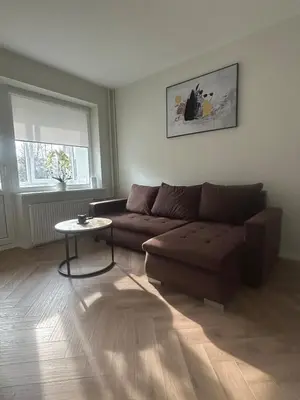 a living room with a brown couch and a table at Kolibris in Kaunas