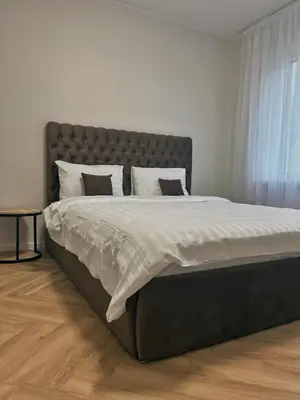 a large bed with white sheets and pillows in a bedroom at Kolibris in Kaunas