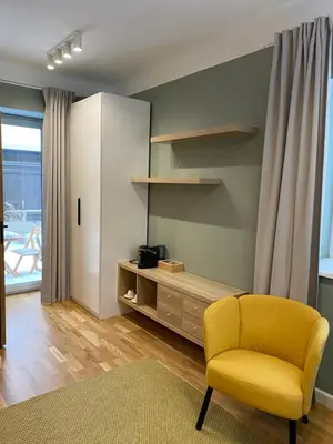 a living room with a yellow chair and a cabinet at 
