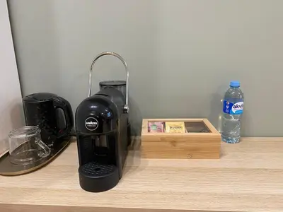 a coffee maker sitting on a counter next to a bottle of water at 