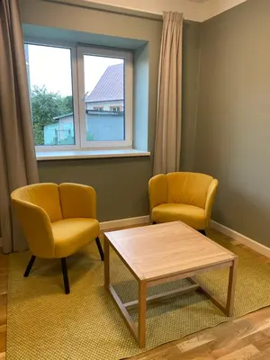 a living room with two chairs and a table and a window at 