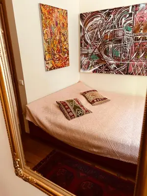 a bed with two pillows in a room with a mirror at Guest room in Old Town in Vilnius