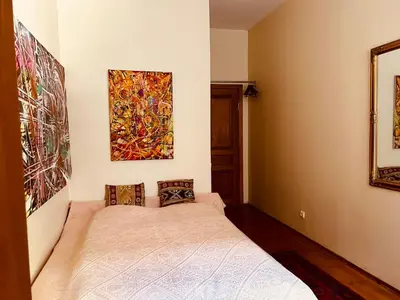 a bedroom with a bed and a painting on the wall at Guest room in Old Town in Vilnius
