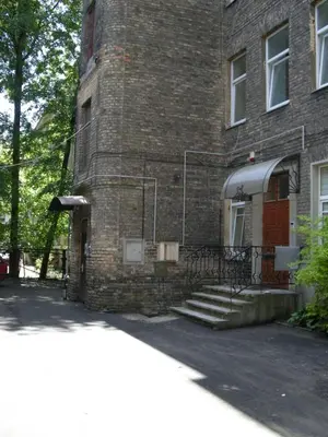 a brick building with a red door and stairs at Guest room in Old Town in Vilnius