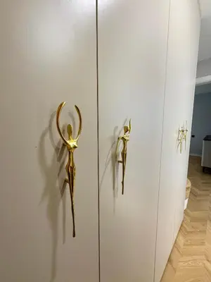 a door with gold handles on a white cabinet at Naujai įrengti apartamentai Morkus Šiauliai in Šiauliai