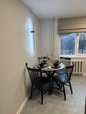 a dining room with a table and chairs and a window at Naujai įrengti apartamentai Morkus Šiauliai in Šiauliai