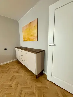 a room with a dresser and a painting on the wall at Naujai įrengti apartamentai Morkus Šiauliai in Šiauliai