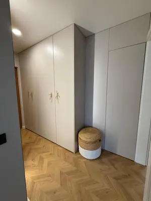 a room with white cabinets and a ottoman at Naujai įrengti apartamentai Morkus Šiauliai in Šiauliai