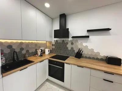 a kitchen with white cabinets and a black stove top oven at Lazdyneliu Vingis Vilnius 